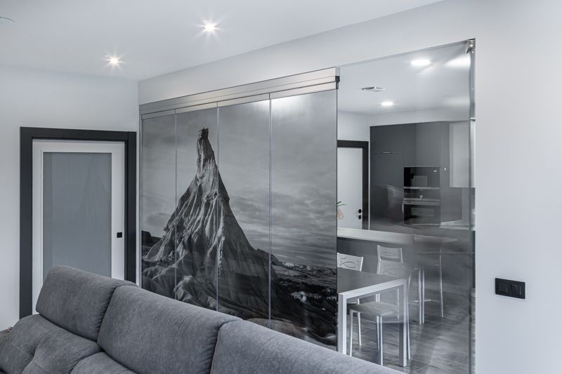 Salón y parte de cocina separados por una cortina de cristal
