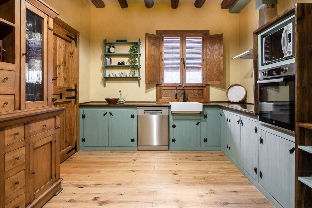 Cocina rústica reformada con muebles verdes y vigas de madera - Casa Dezerto, arquitectura en Navarra