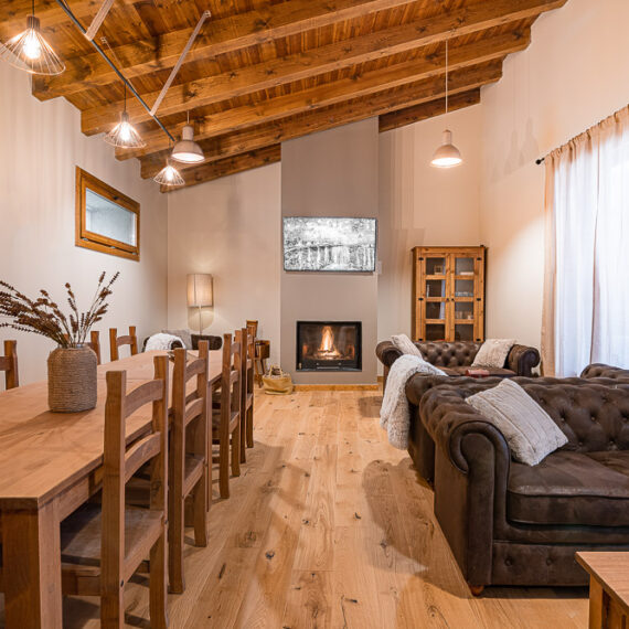 Salón con chimenea, sofá chester y techo de madera - proyecto de arquitectura en Ribera de Navarra