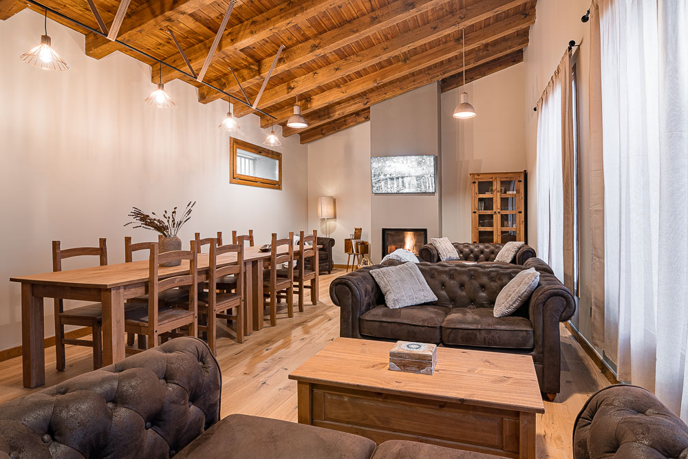 Comedor y salón integrados con techo abuhardillado de madera - Casa Dezerto, Navarra