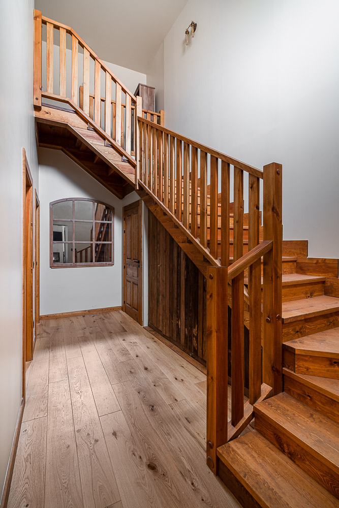 Escalera de madera artesanal en vivienda rural reformada en Navarra