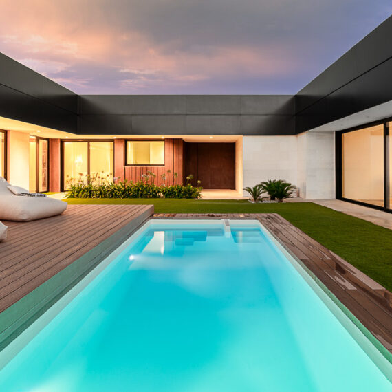 Vista nocturna de la piscina con iluminación interior de la vivienda - Casa Silis, Navarra