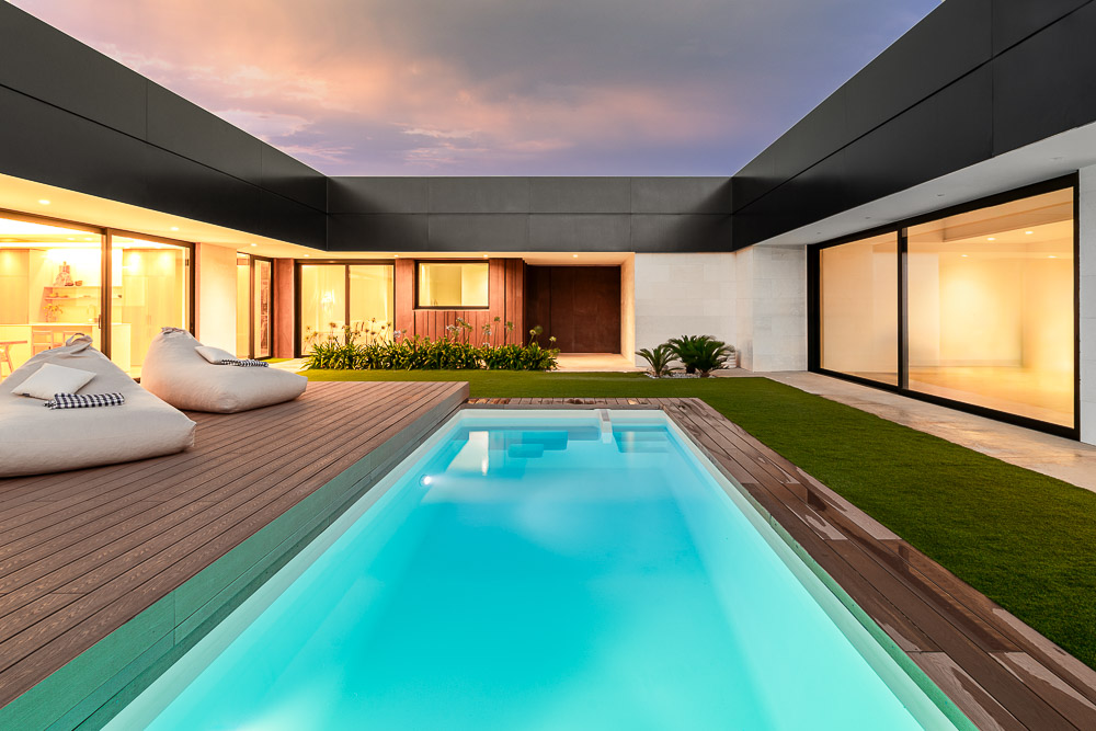 Vista nocturna de la piscina con iluminación interior de la vivienda - Casa Silis, Navarra