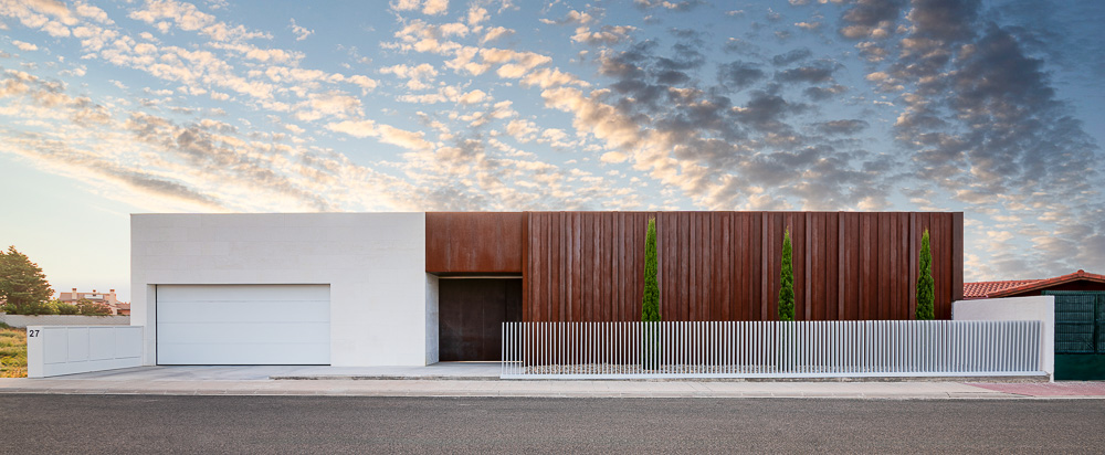 Fachada principal de vivienda moderna con acero corten y piedra - Casa Silis, Navarra
