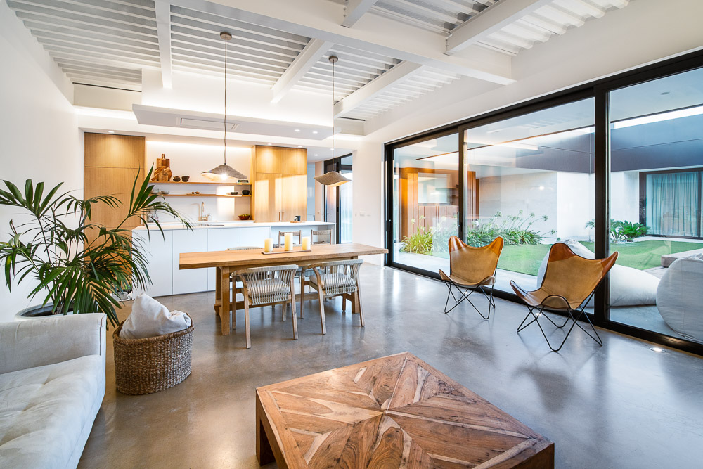 Salón comedor abierto con cocina de madera y grandes ventanales - Casa Silis, Arquitectura de la Ribera