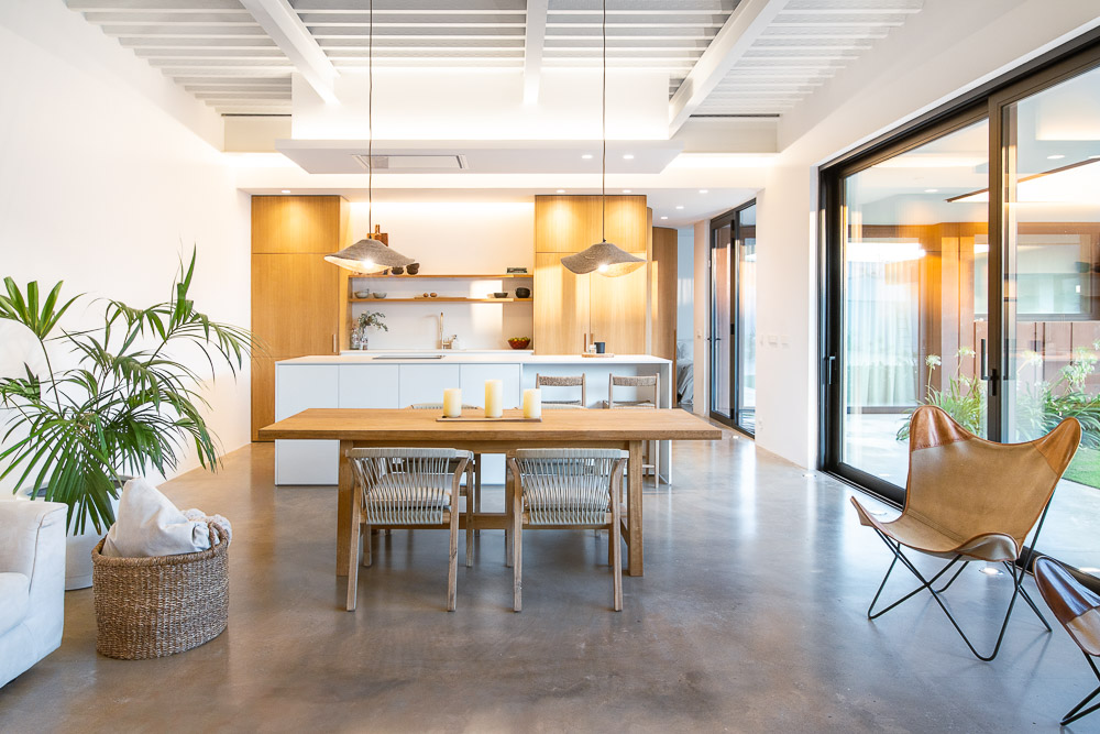Cocina y comedor integrados con isla central y vistas al jardín - vivienda unifamiliar en Navarra