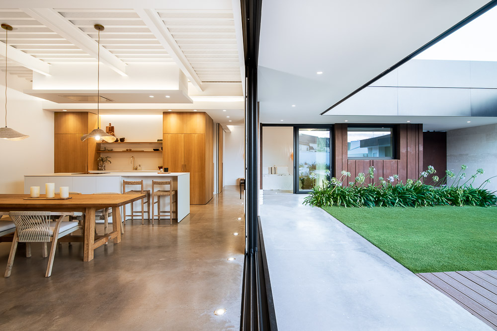 Espacio interior conectado visualmente con el jardín y patio exterior - Casa Silis, Navarra