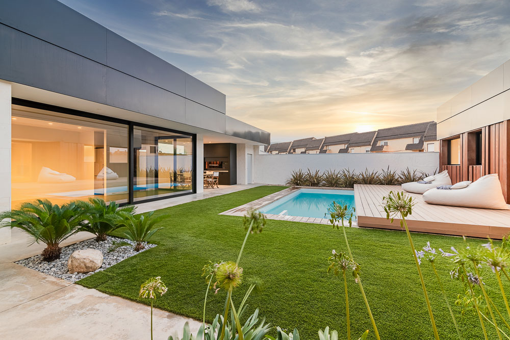 Piscina y zona chill out con tumbonas de exterior al atardecer - vivienda unifamiliar en Navarra