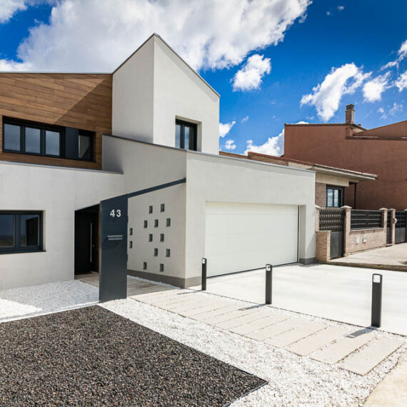 Fachada diurna de vivienda unifamiliar moderna con revestimiento de madera - Casa Tilio, Navarra