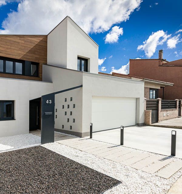 Fachada diurna de vivienda unifamiliar moderna con revestimiento de madera - Casa Tilio, Navarra