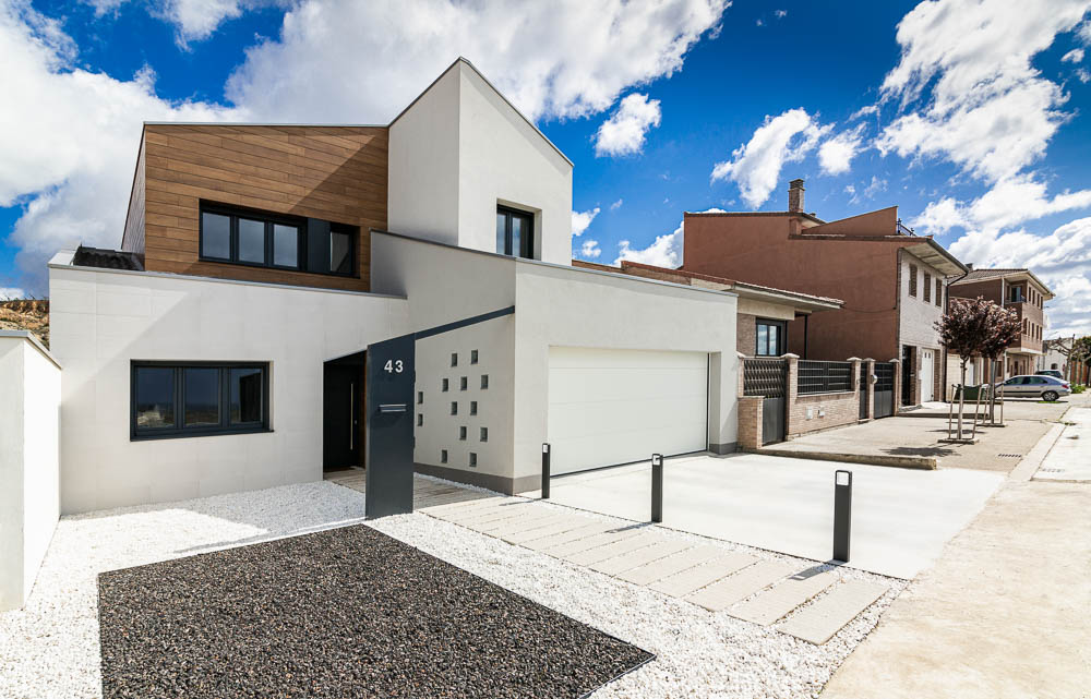 Fachada diurna de vivienda unifamiliar moderna con revestimiento de madera - Casa Tilio, Navarra