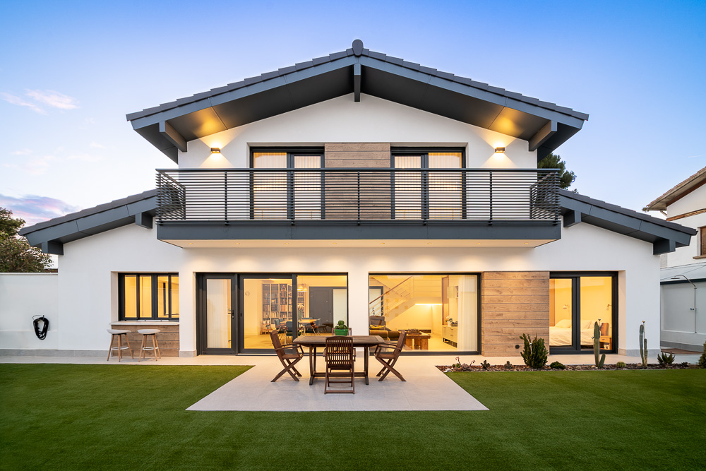 Porche iluminado con comedor exterior y gran jardín, arquitectura de vivienda unifamiliar por Arquitectura de la Ribera