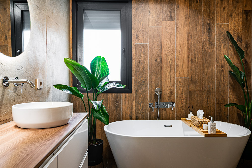 Bañera exenta junto a pared efecto madera, reforma de baño por estudio de arquitectura en Navarra