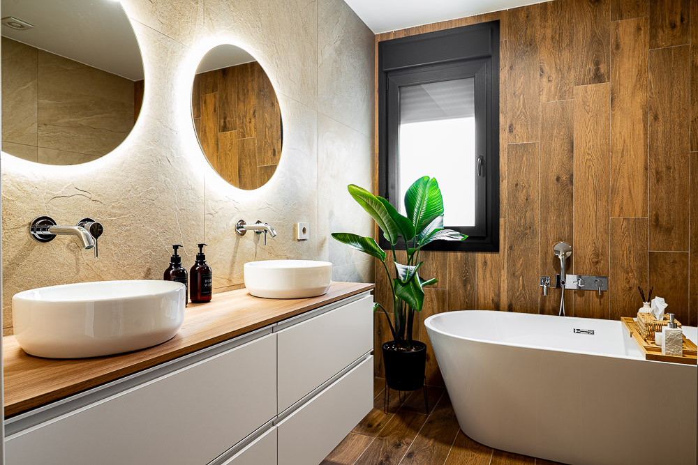 Baño principal con lavabos sobre encimera y bañera exenta, interiorismo de Arquitectura de la Ribera