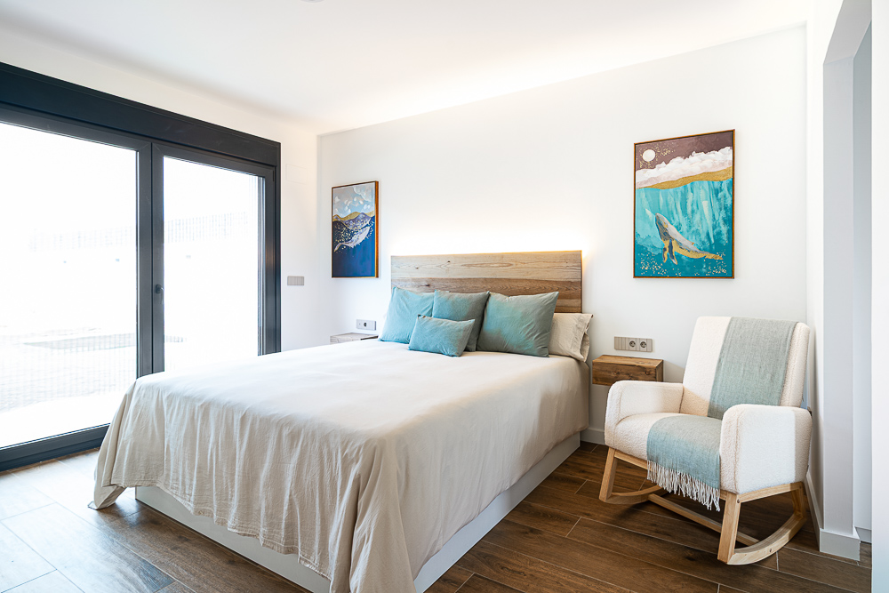 Dormitorio principal con gran ventanal negro, vivienda diseñada por Arquitectura de la Ribera en Cintruénigo, Navarra