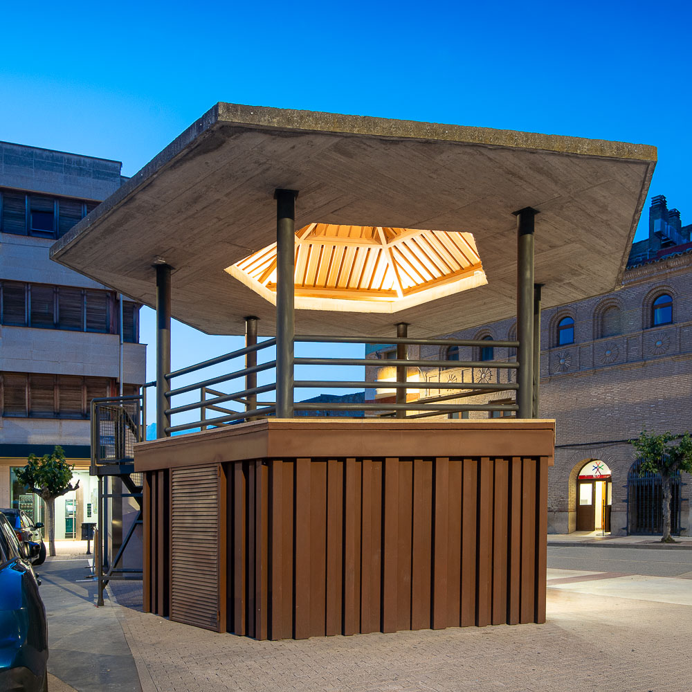 Detalle del revestimiento de madera y el techo de lamas iluminado al anochecer, proyecto de arquitecto en Navarra
